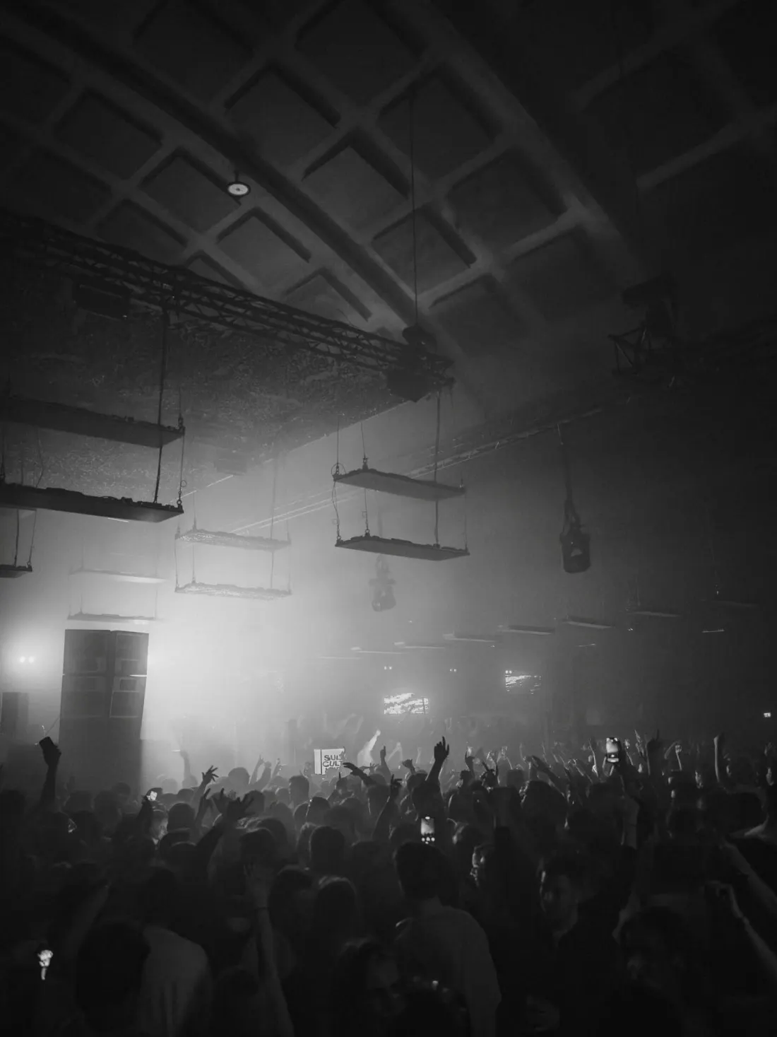 A packed hall under the trusses, in black and white